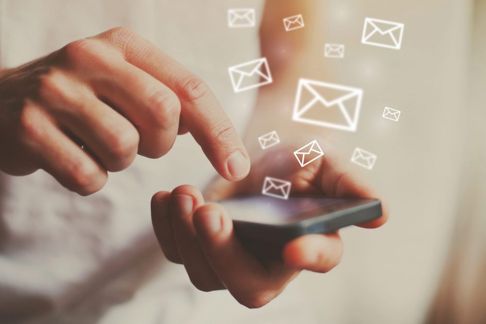 email marketing symbols coming out of a phone